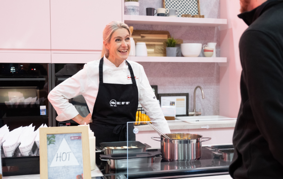 Shot of someone at the show kitchen of the NEFF Kitchen Display Exhibition Stand.