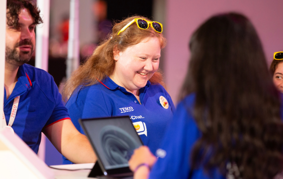 Shot of a woman in a blue Tesco shirt and yellow sunglasses at Tesco Live