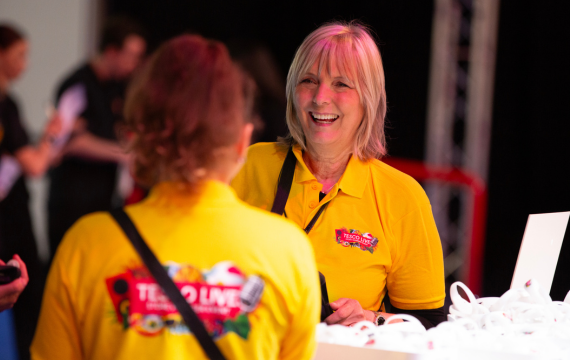 Shot of two people in yellow tshirts at Tesco Live